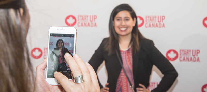 Person getting photo taken in front of step and repeat