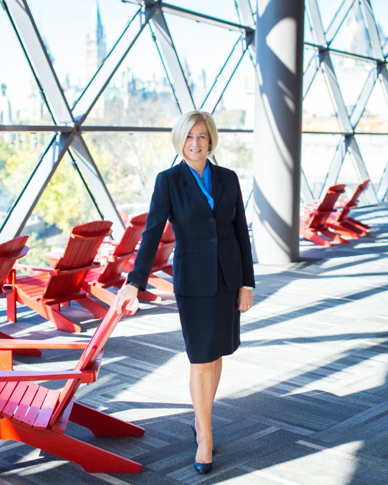 Nina Kressler standing by a red chair