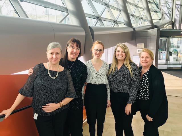 five female staff members in similar shirts