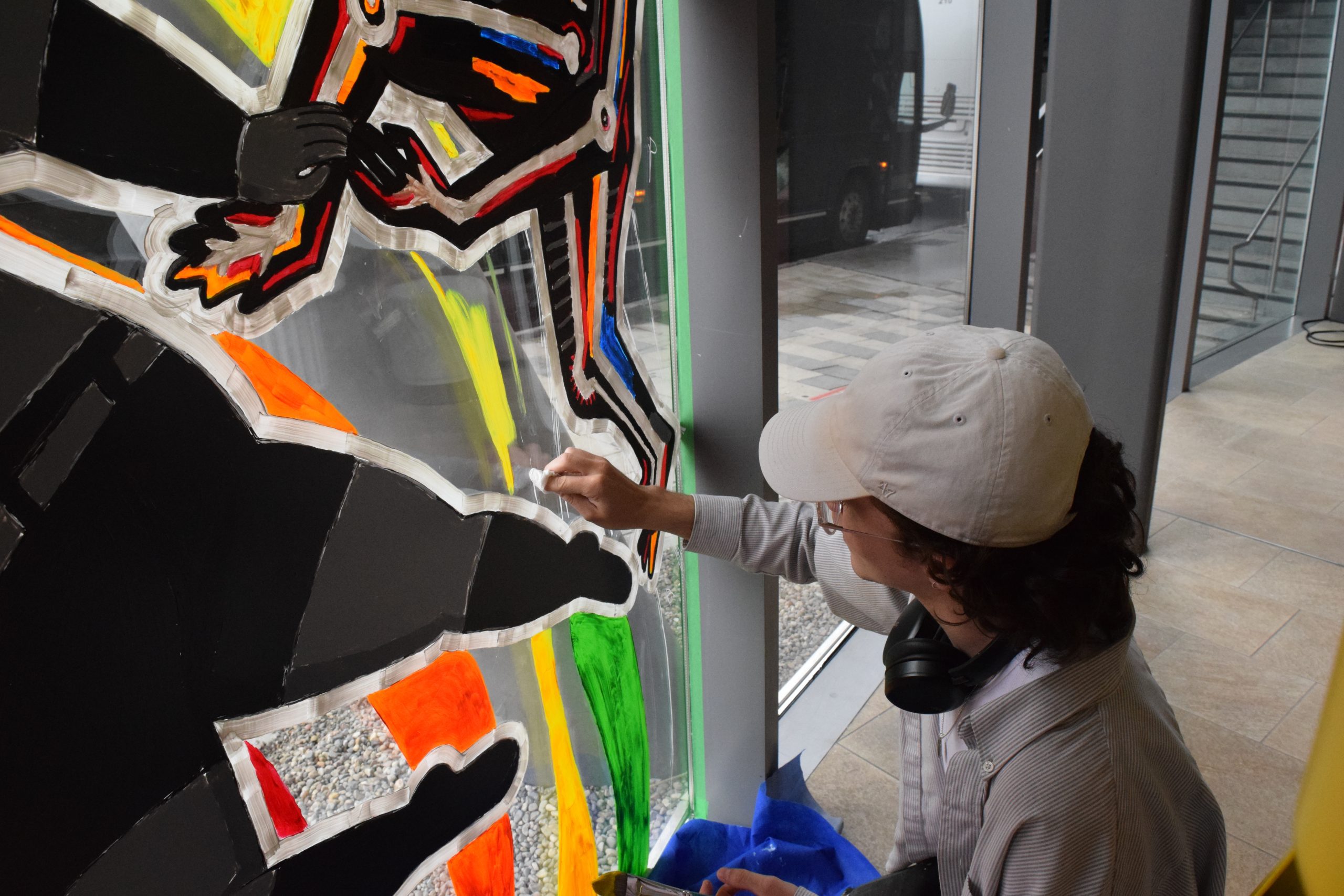 Photo of Anthony Leger working on Pride Mural