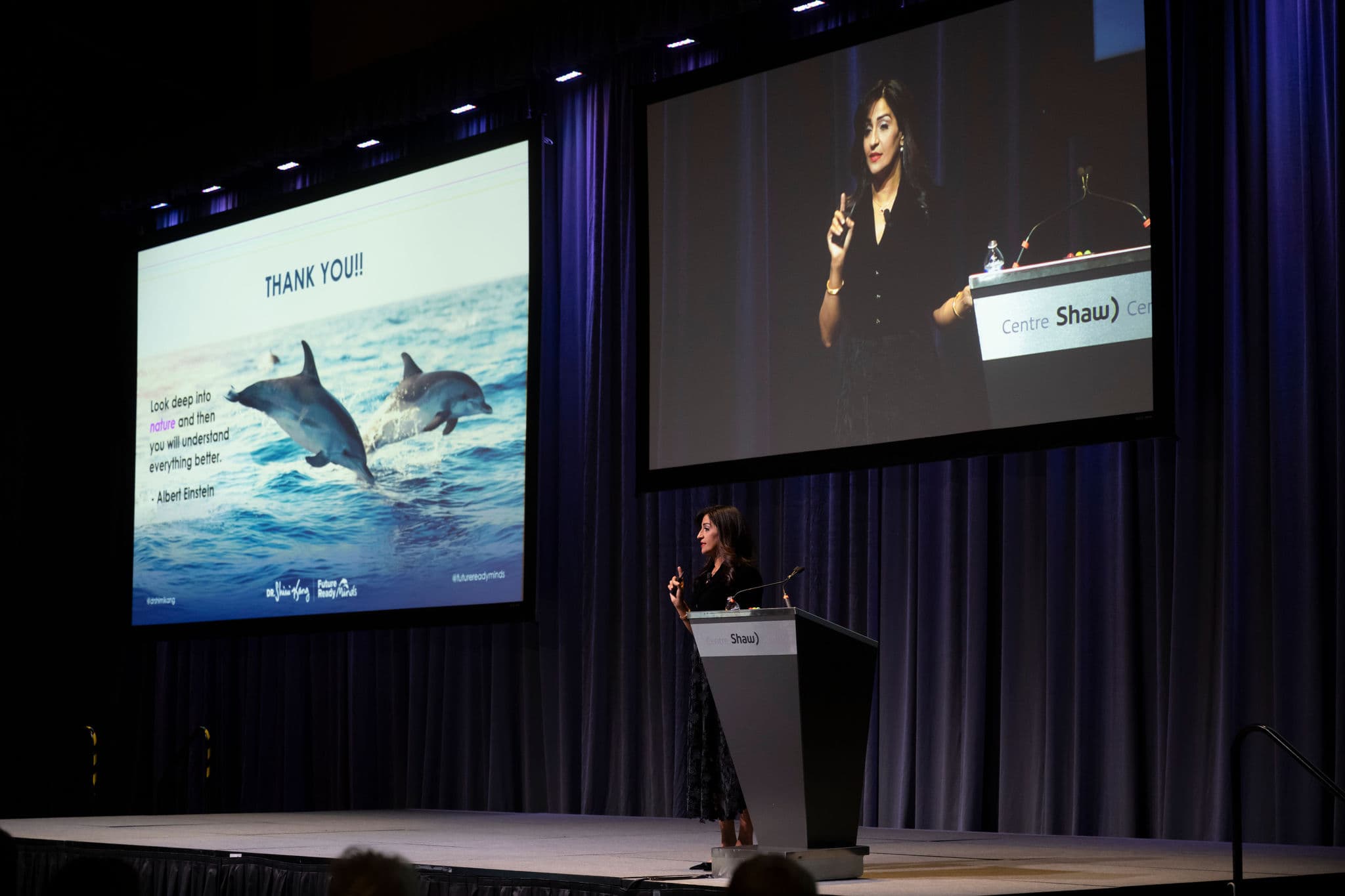 Dr. Shimi Kang giving her speech with projector on the background