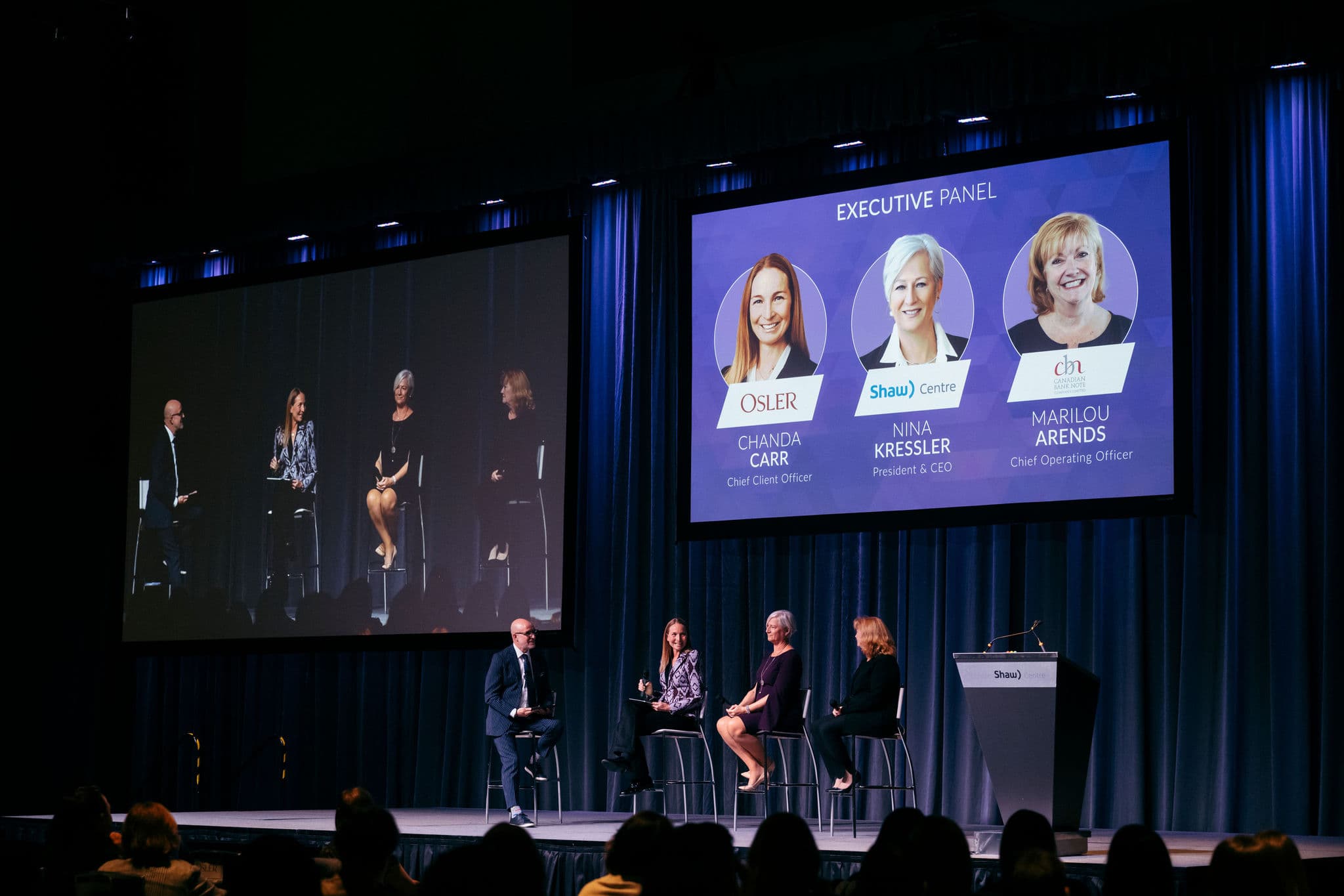 Executive Panel sits on the stage with host