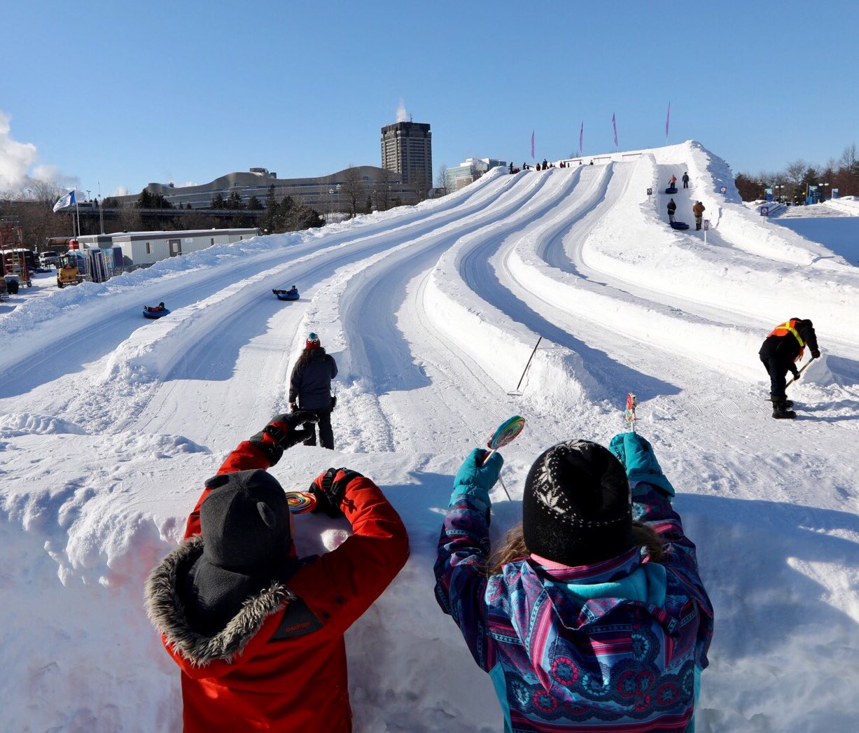 Kids sitting at the top of the snow hill