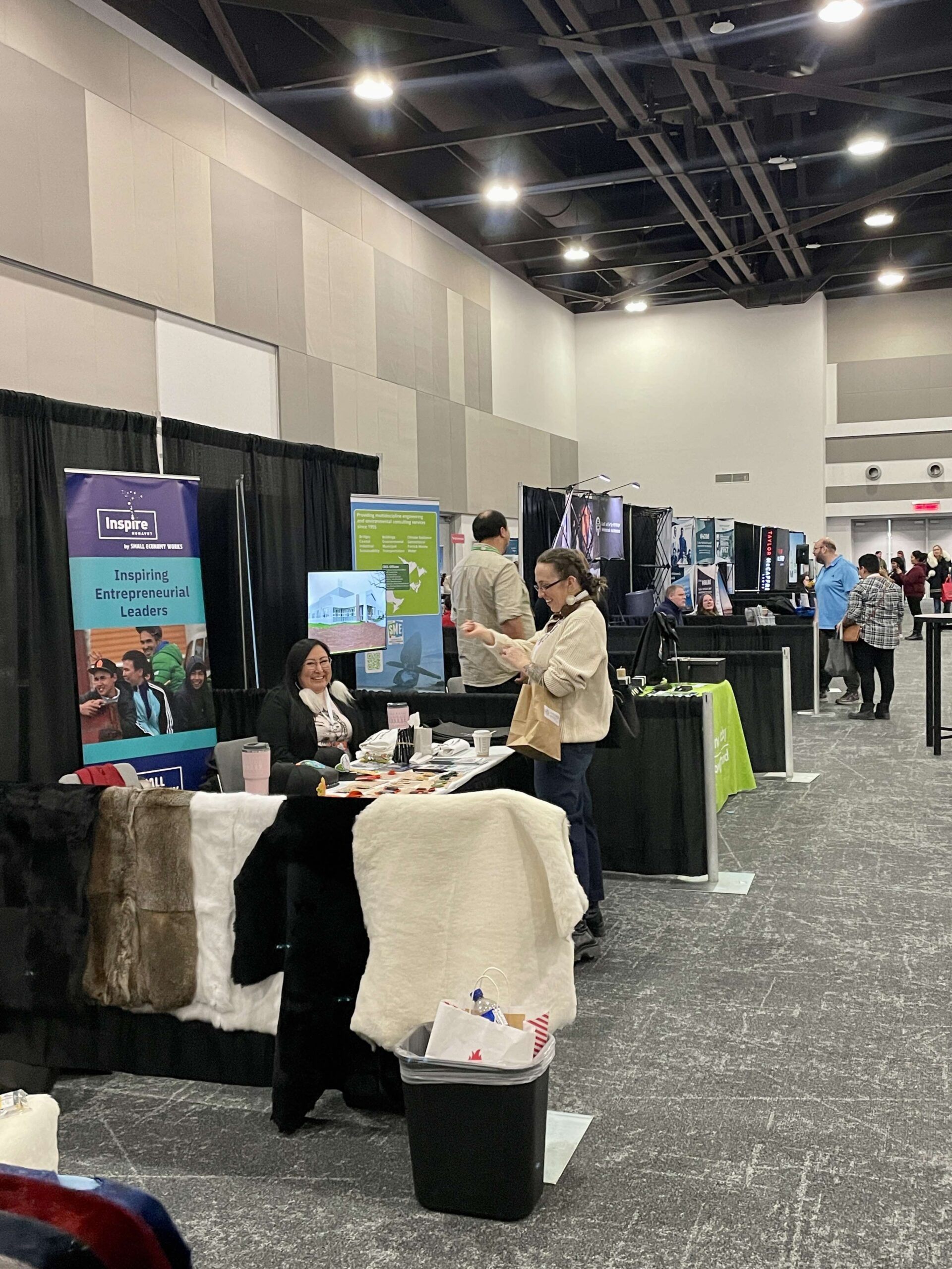 Trade show floor with people interacting at the booth